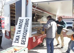 A tady už se vše nakládá do auta přizpůsobeného k výdeji potravin, které zamířilo s dobrovolníky na Ukrajinu, kde se z něj v současné době zdarma vydává jídlo a pití na hranicích. Na desce je v ukrajinštině nápis Jídlo a pití zdarma