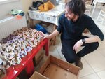 Sociální pracovník Klíčku a pastorační asistent charity skládá hotové svíčky do krabic. 